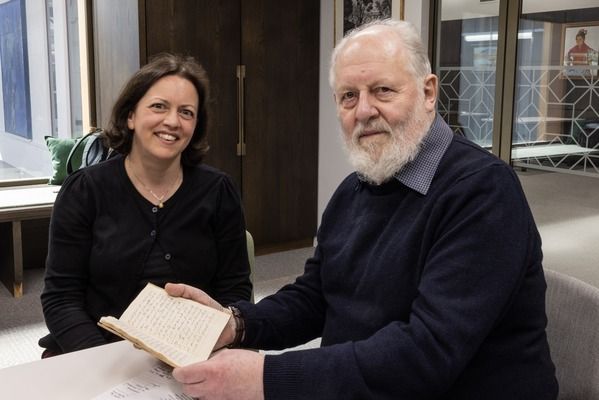 Dr Alex Bamji and Peter Brears sitting at a table together holding the pamflyt compiled of Cheese